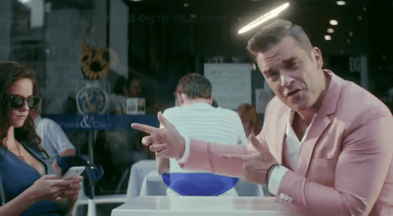 First Look: Robbie Williams Rocks Out In Pink In His New ‘Candy’ Music Video