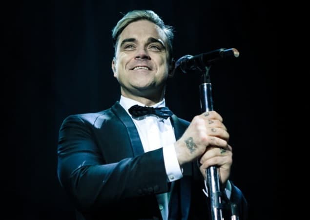 VIDEO – Robbie Williams Falls Off Stage At Gig, Breaks Fan’s Hand
