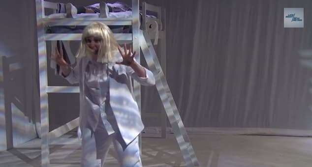 WATCH: Sia Performs “Chandelier” Facedown On A Bed While Lena Dunham Dances Around Her